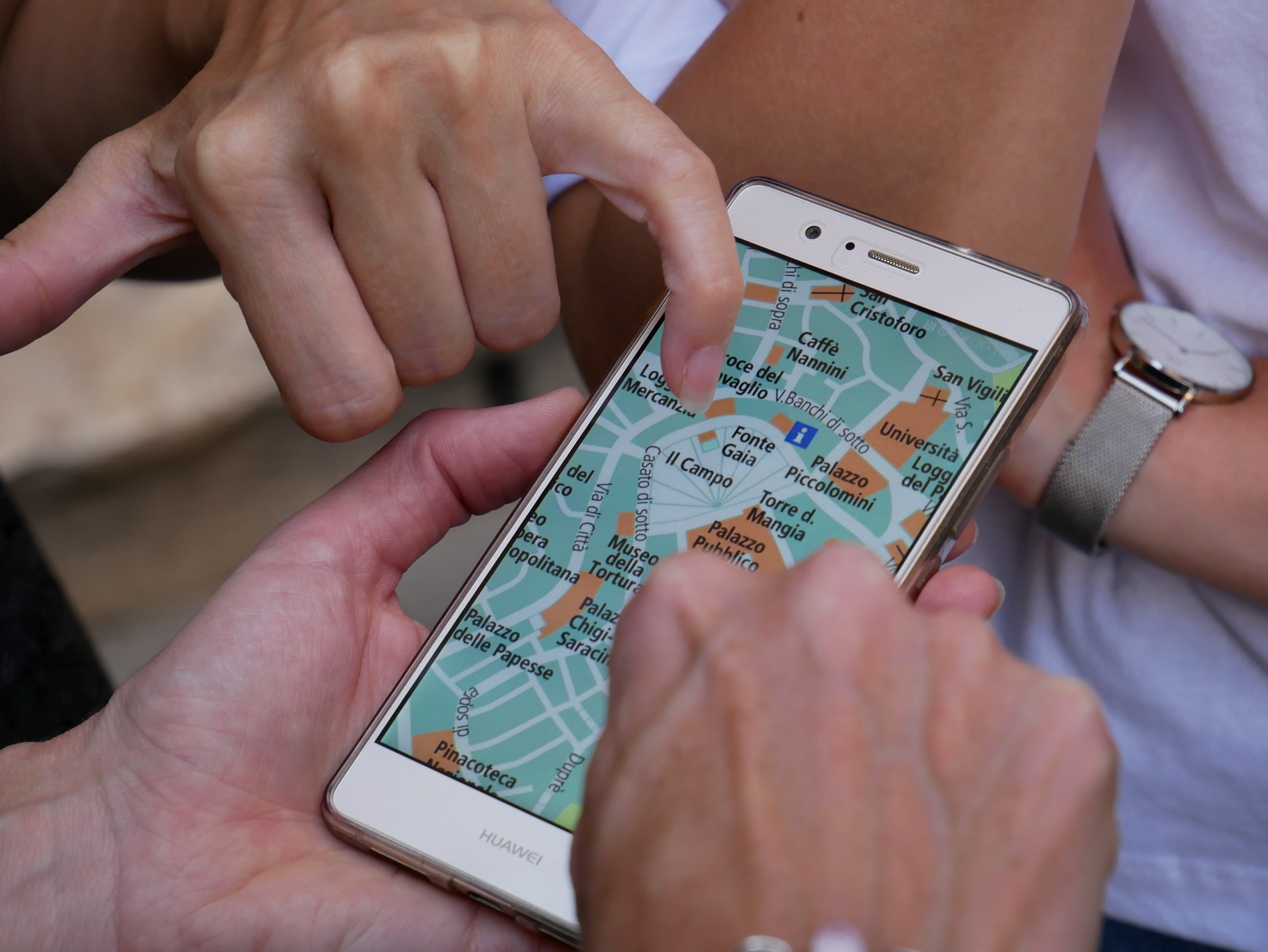 Two people look at a GPS on a smartphone.