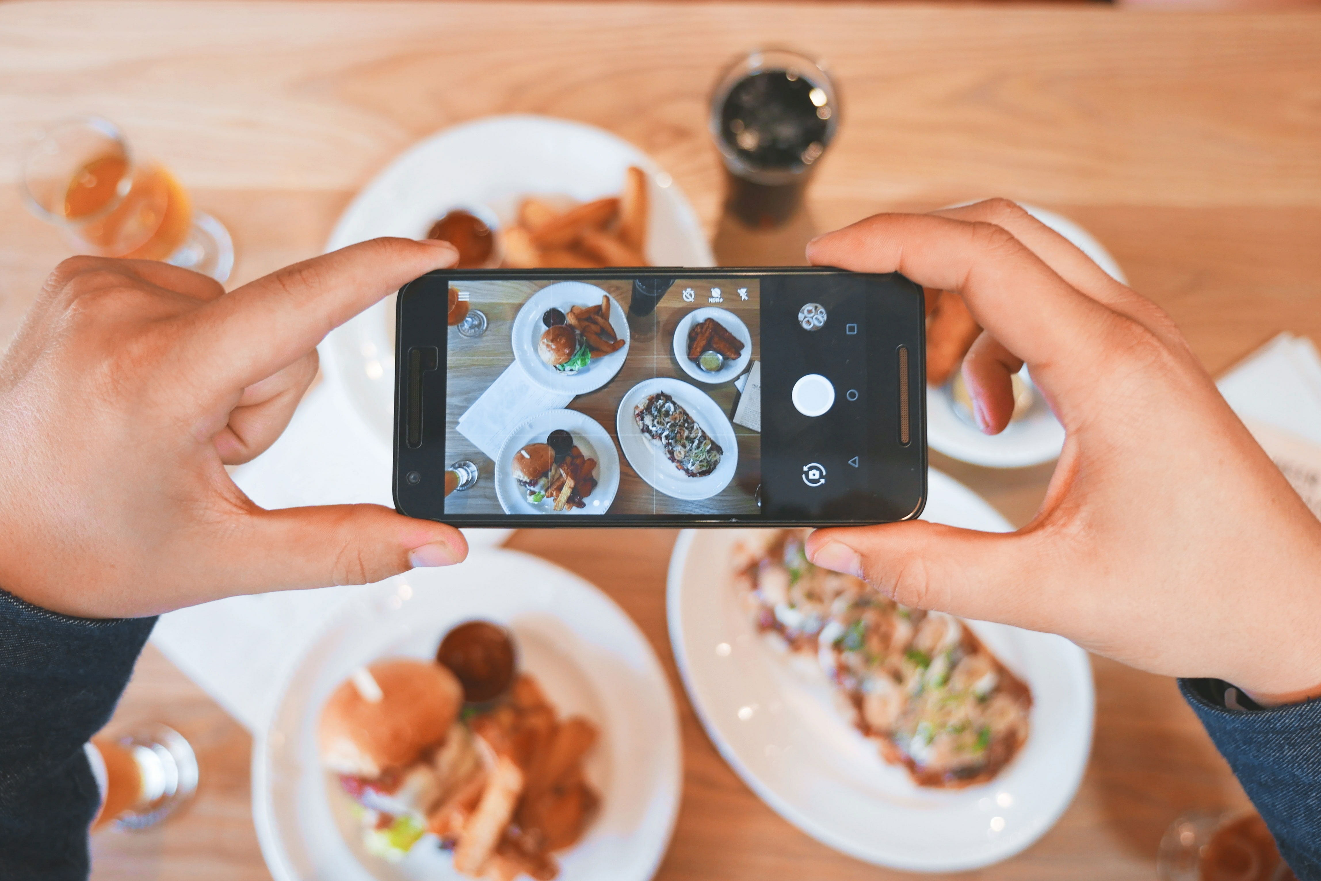 Someone taking a photo of food on white plates.
