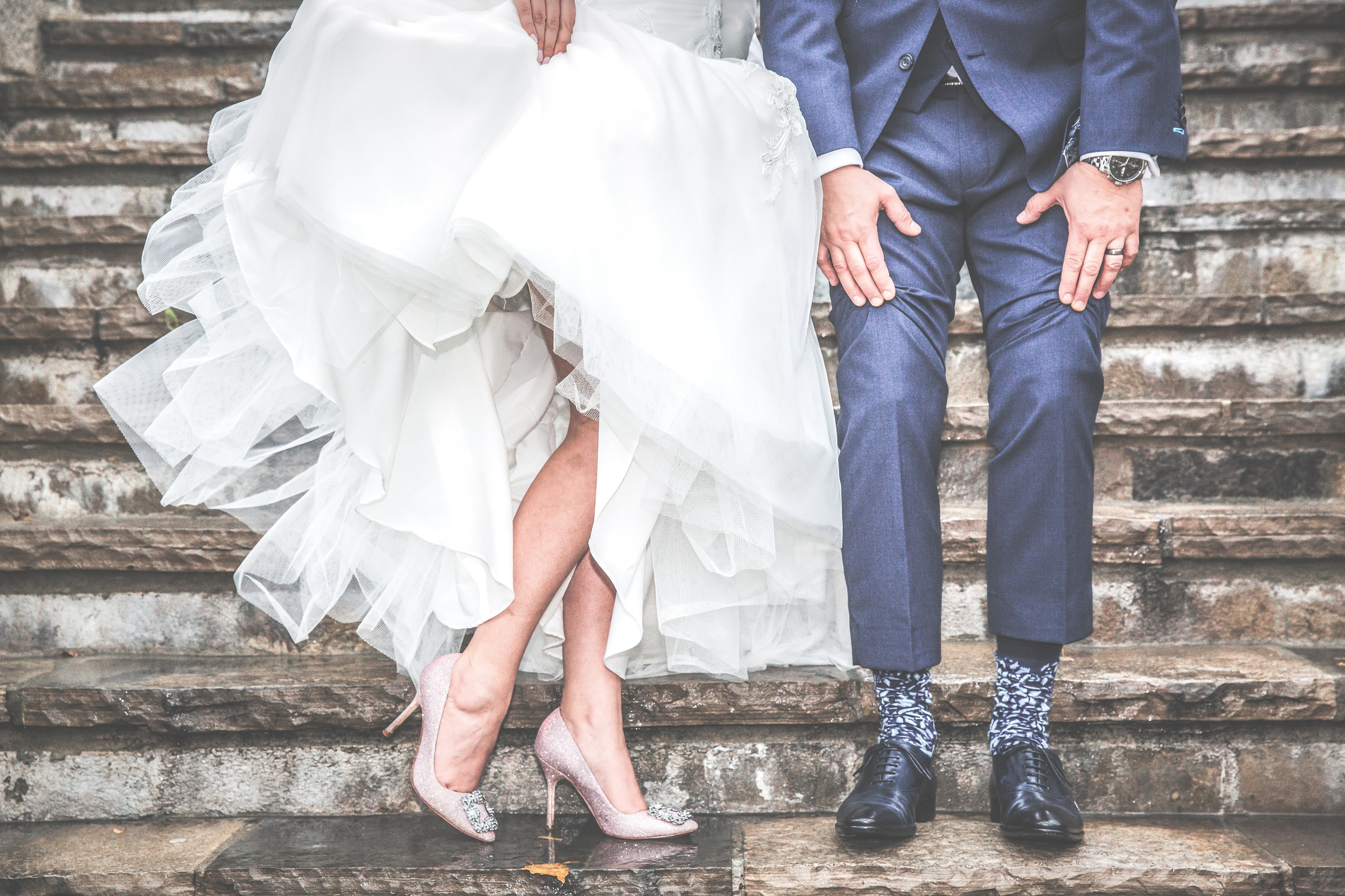Bride and groom standing on stone steps.