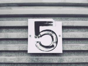 number five painted onto a small placard nailed onto a metal surface