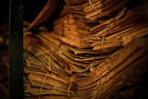 old papers tied up with string stacked in a pile