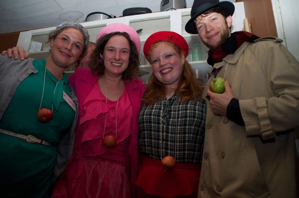 four people pose with apples for a costume