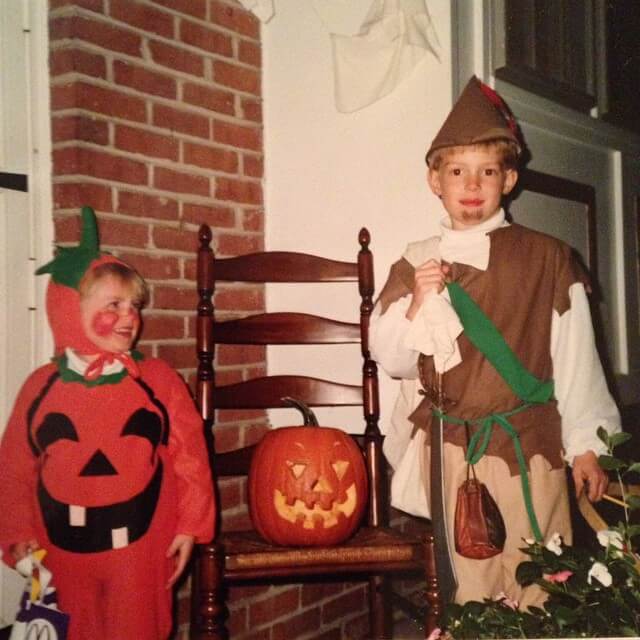 two young boys, one dressed as a pumpkin and one as robin hood for halloween