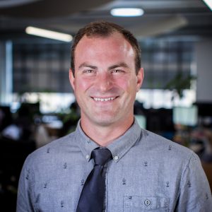 a man smiles while standing in an office