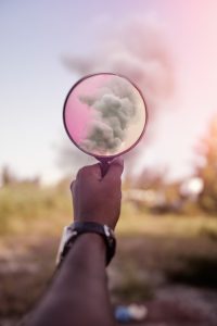 Pink magnifying glass held up to the clouds.