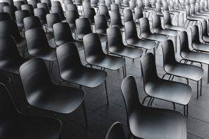 rows of empty chairs line a dark room