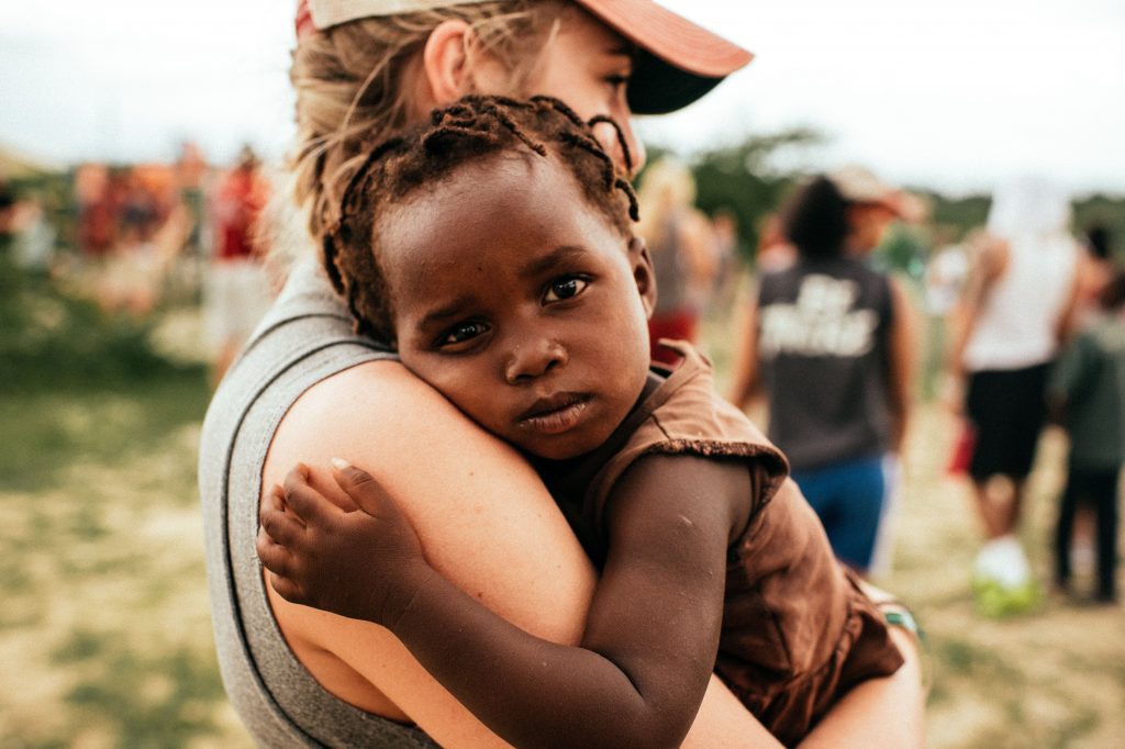 An impoverished child being held by an activist.