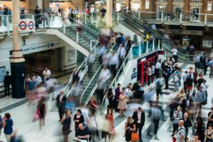 A crowded subway station with motion blur of people moving.