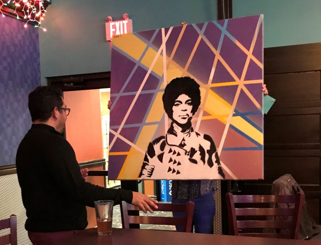 Oneupweb owner being presented with a Chase Hunt painting of Prince.