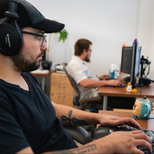 A male Oneupweb developer working at his desk.