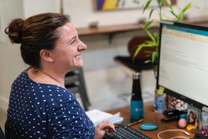 A female account manager sending an email on her computer.
