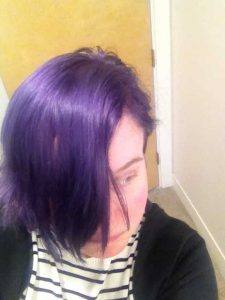 woman with very short purple hair poses for a selfie