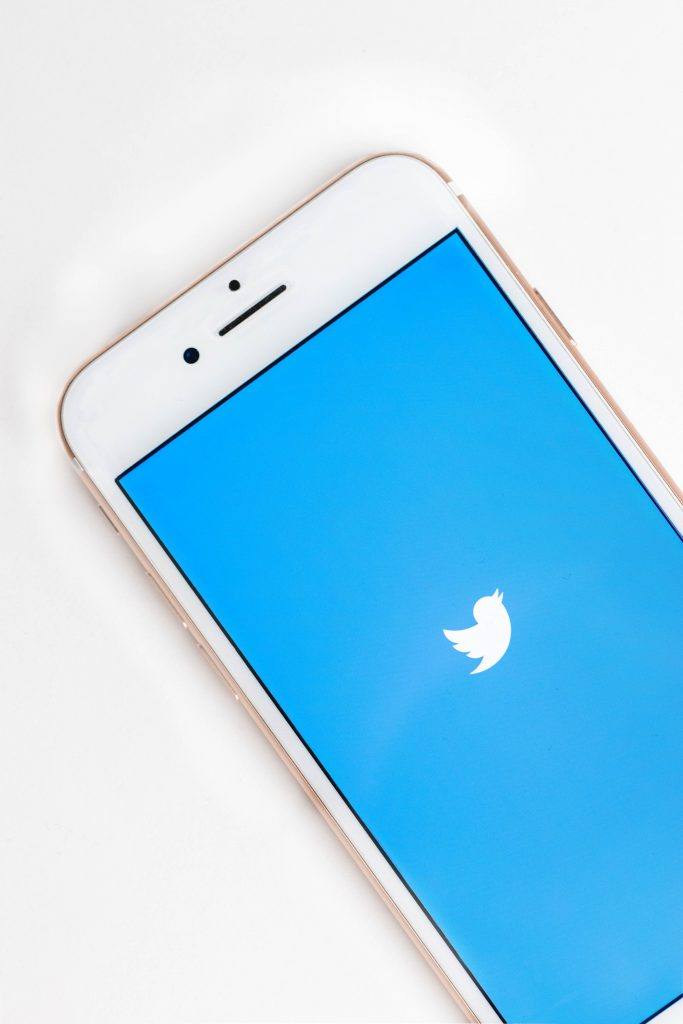 phone open to twitter loading screen sits on a plain desk