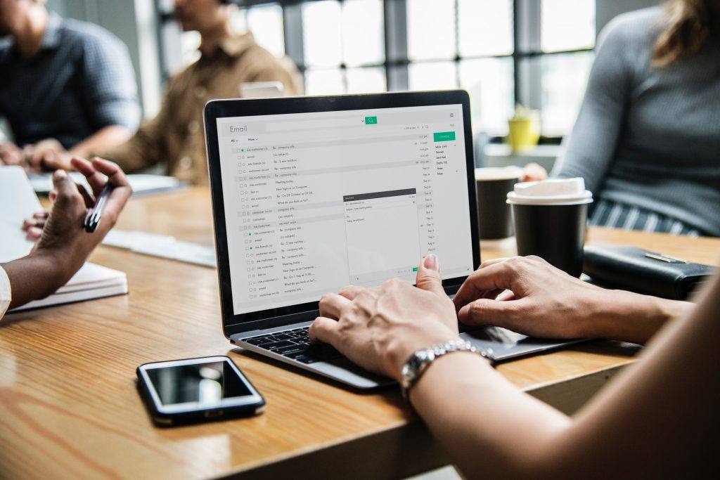 person with a laptop typing in their email on a desk