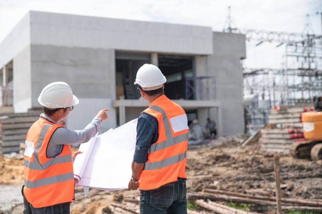 two construction workers talking and pointing