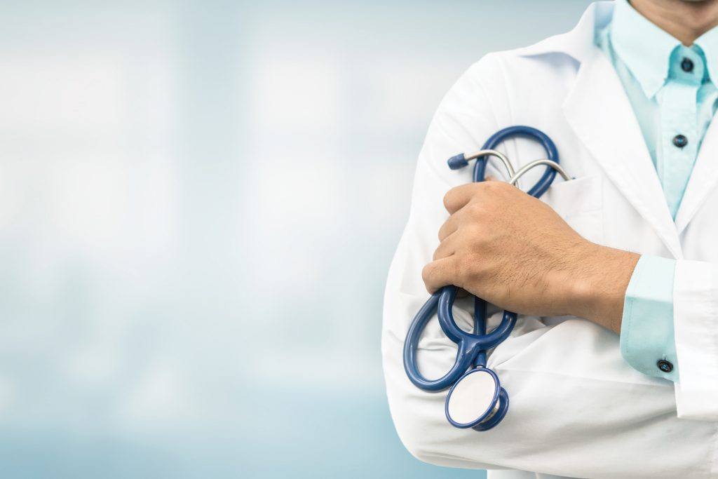 Close-up view of doctor's hand holding a stethoscope