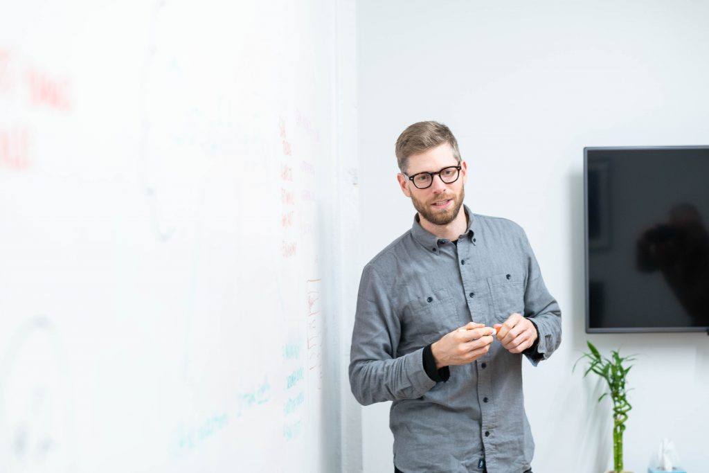 Professional man holds dry erase marker in meeting room