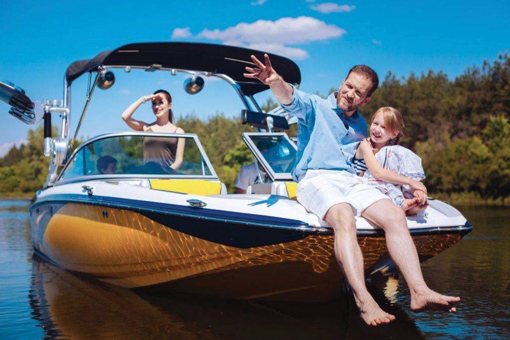 Man, woman, and child relax on a luxurious speedboat with a sunshade