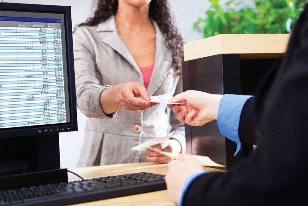 Bank teller hands customer a receipt