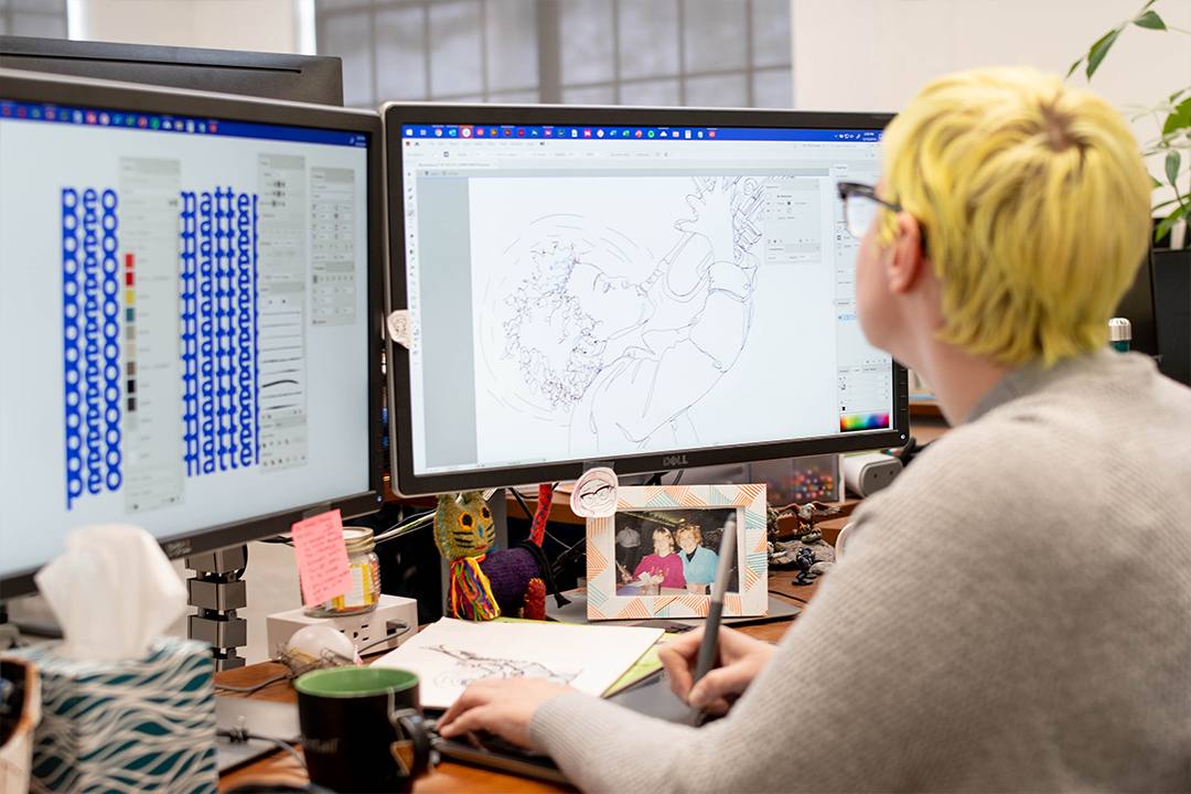 one of oneupweb's graphic designers works on her computer