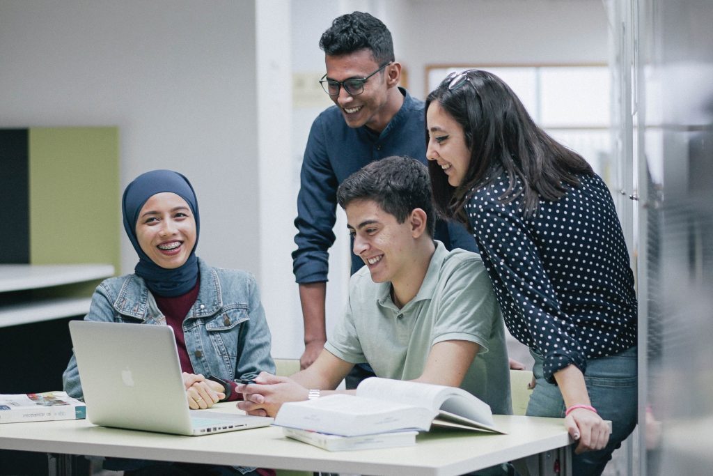 University students gather around laptop