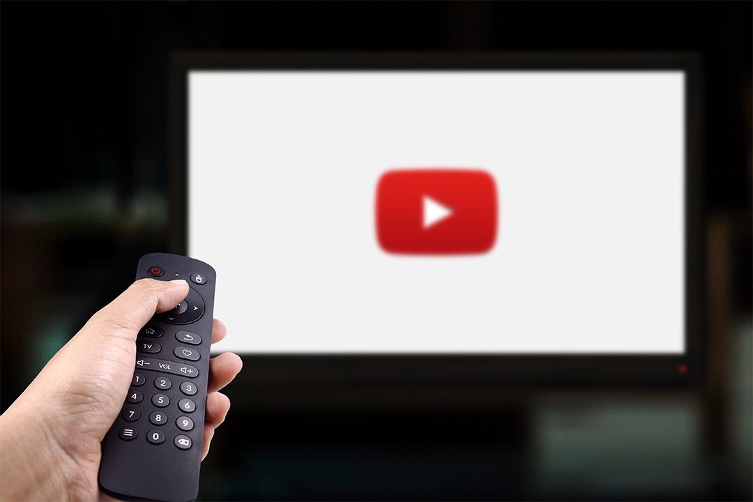 Person holds TV remote while watching Youtube on Smart TV