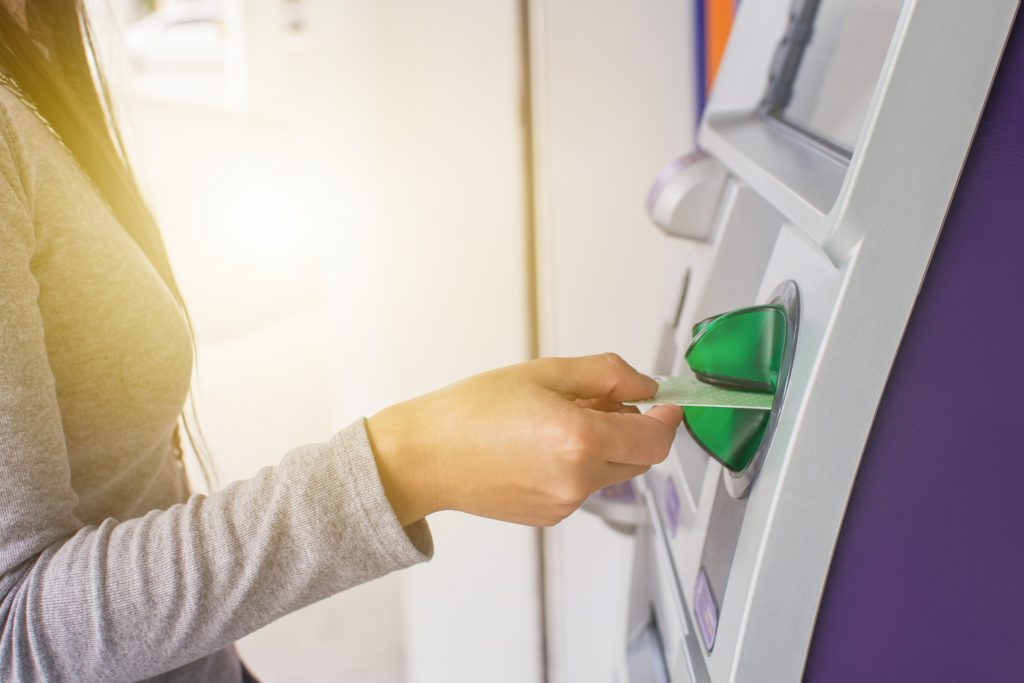 Banking customer puts payment card in ATM