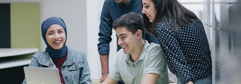 University students gather around laptop