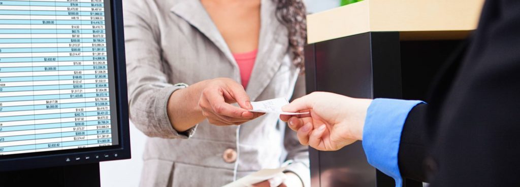 Bank teller hands customer a receipt