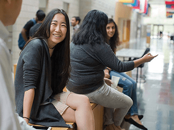 Women chat in a hallway of a university