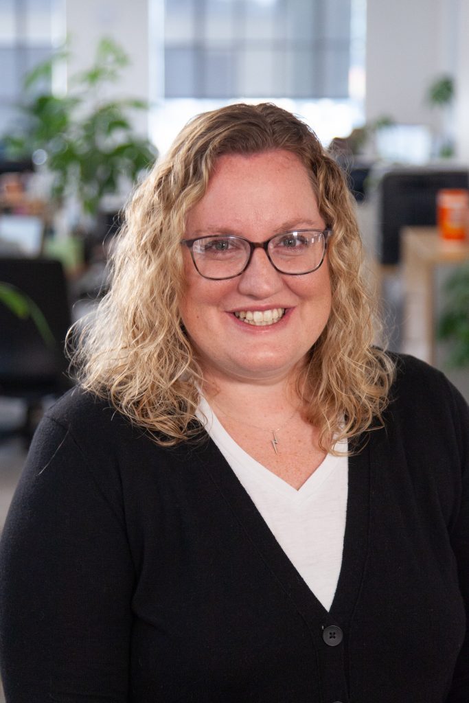 Headshot of Oneupweb employee smiling in office