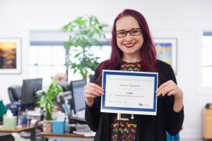 Oneupweb employee smiling while holding an ABA Professional Certification