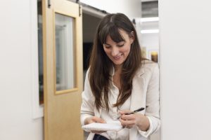 Female marketing expert looks down at her notebook and pen