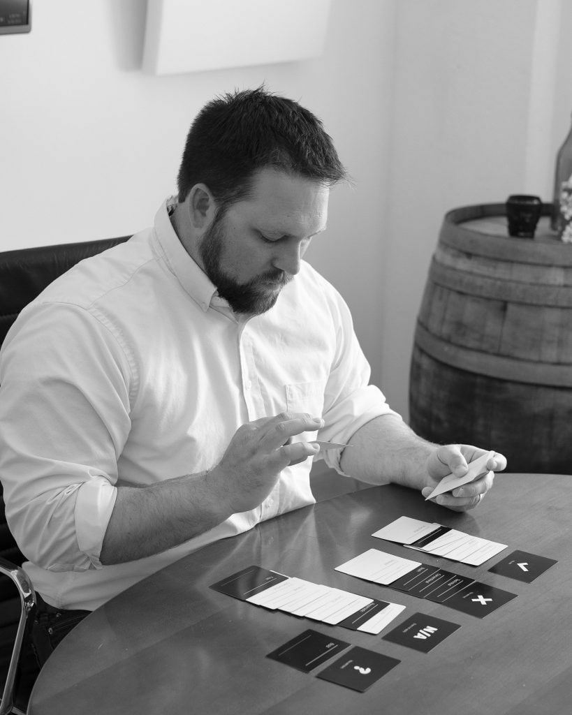 Man sits at table performing a brand workshop exercise with flash cards