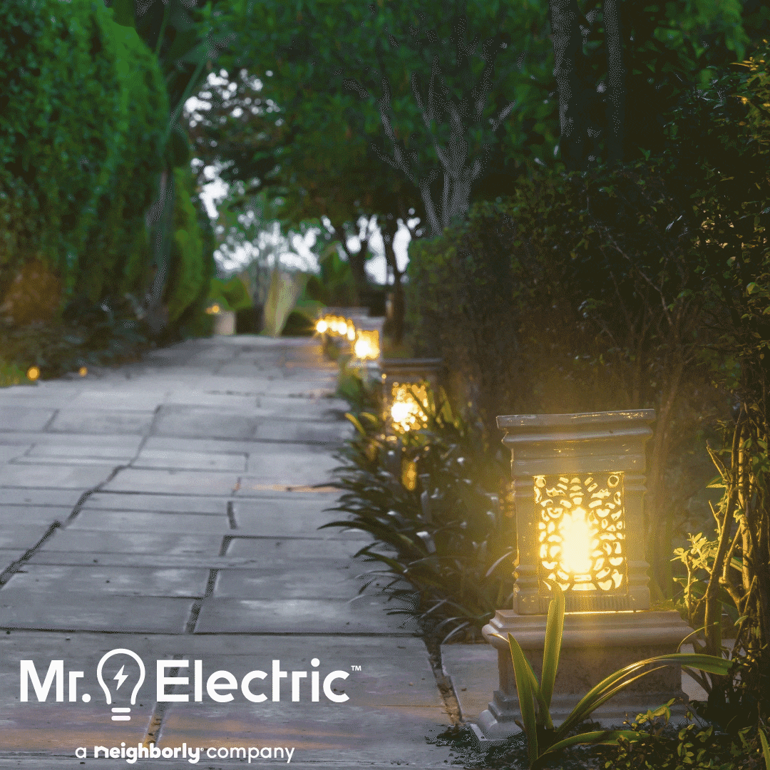 Mr. Electric logo is shown on a beautiful walkway surrounded by low lighting and trees
