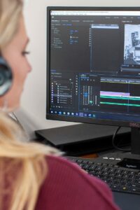 a woman uses computer software for creating videos on a computer