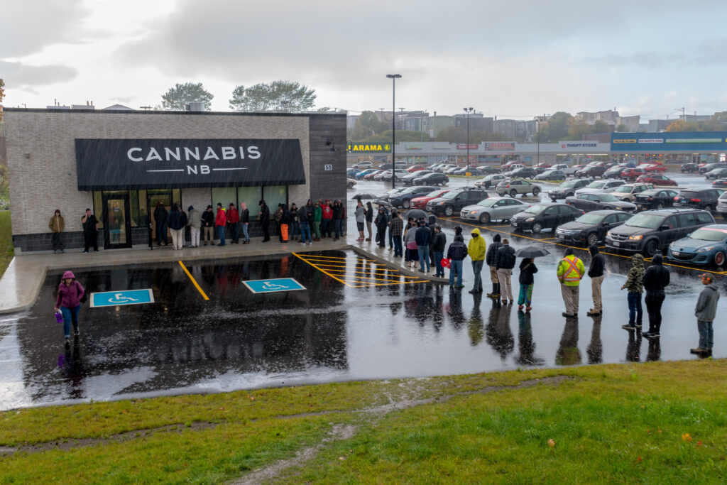 a line of customers wait to enter a marijuana dispensary