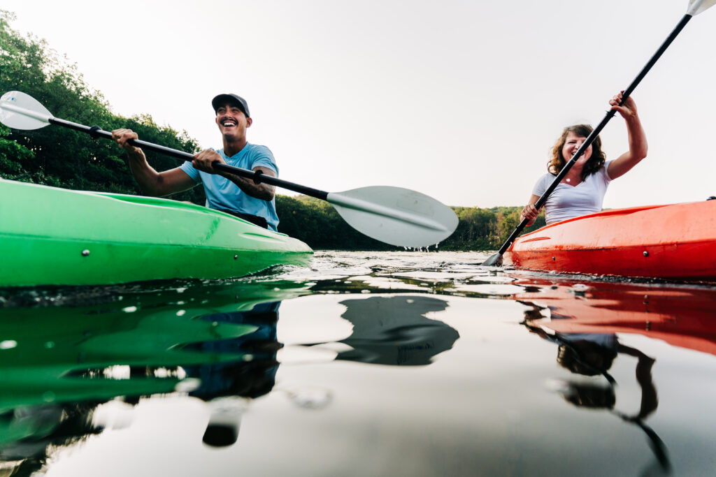 two kayakers paddle on a lake on a sunny day