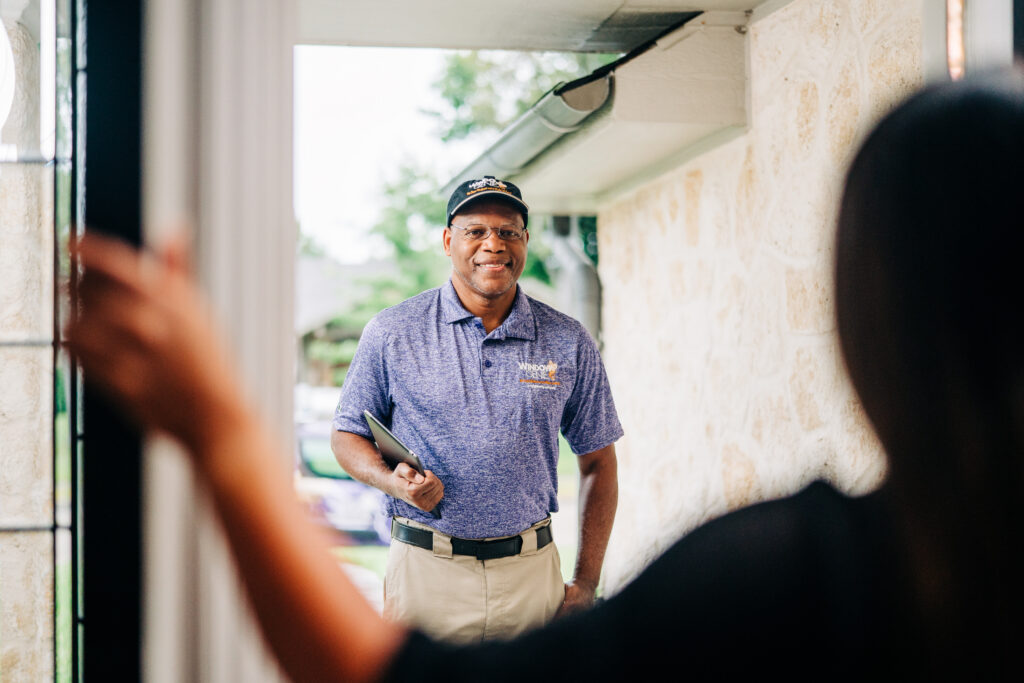 a worker greets a woman at her door