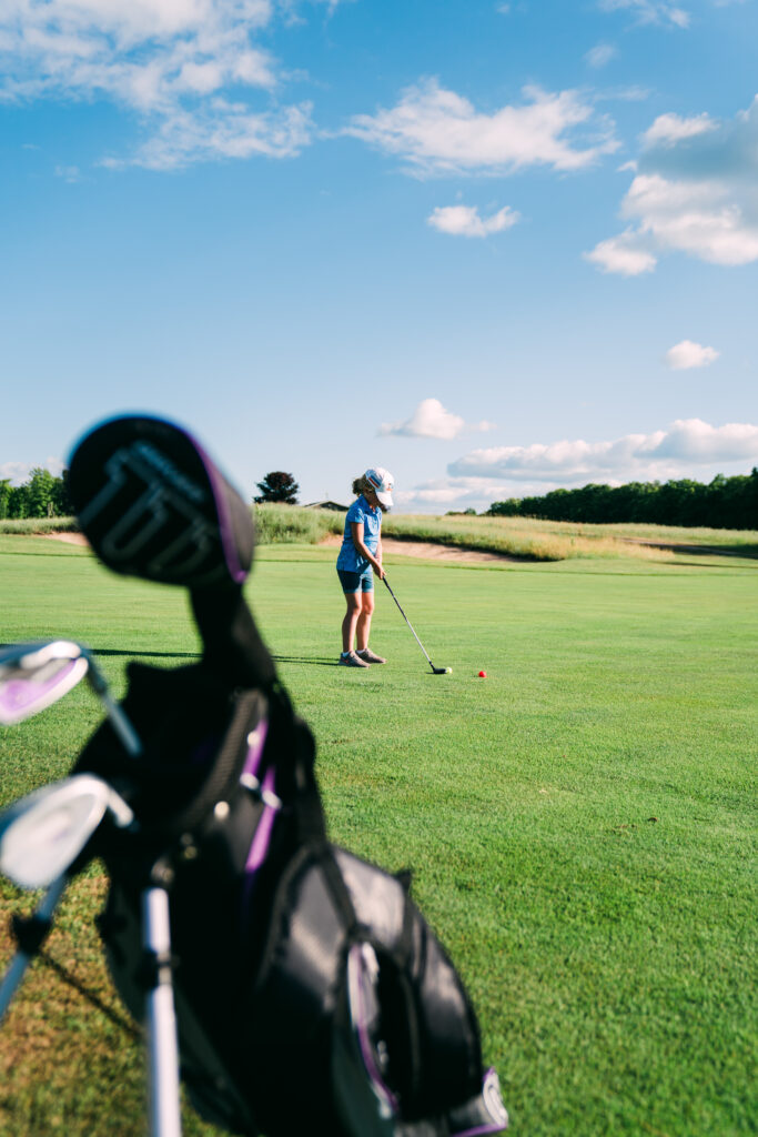 a golfer lines up her shot on a sunny day