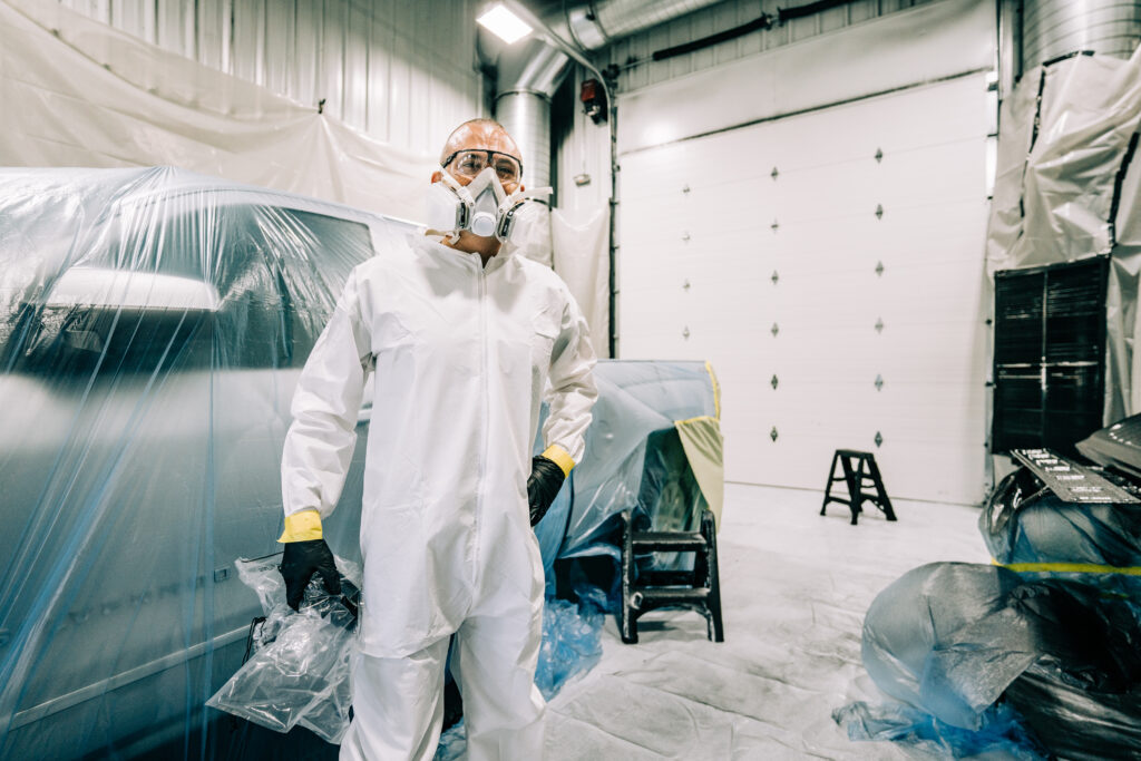 a car detailer is dressed in plastic before working