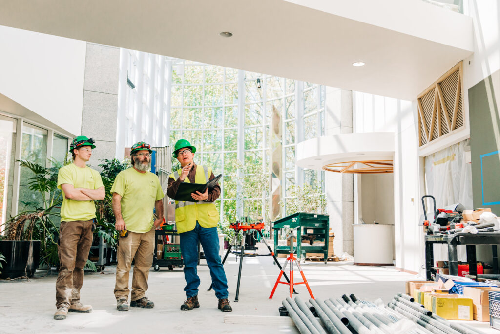 three construction workers look around their work space