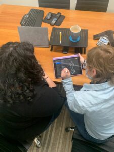 jess and nicole check out a design on a tablet at the current oneupweb office