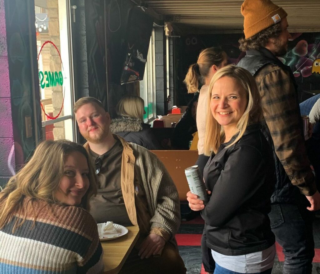 Oneupweb employees laughing at the arcade.