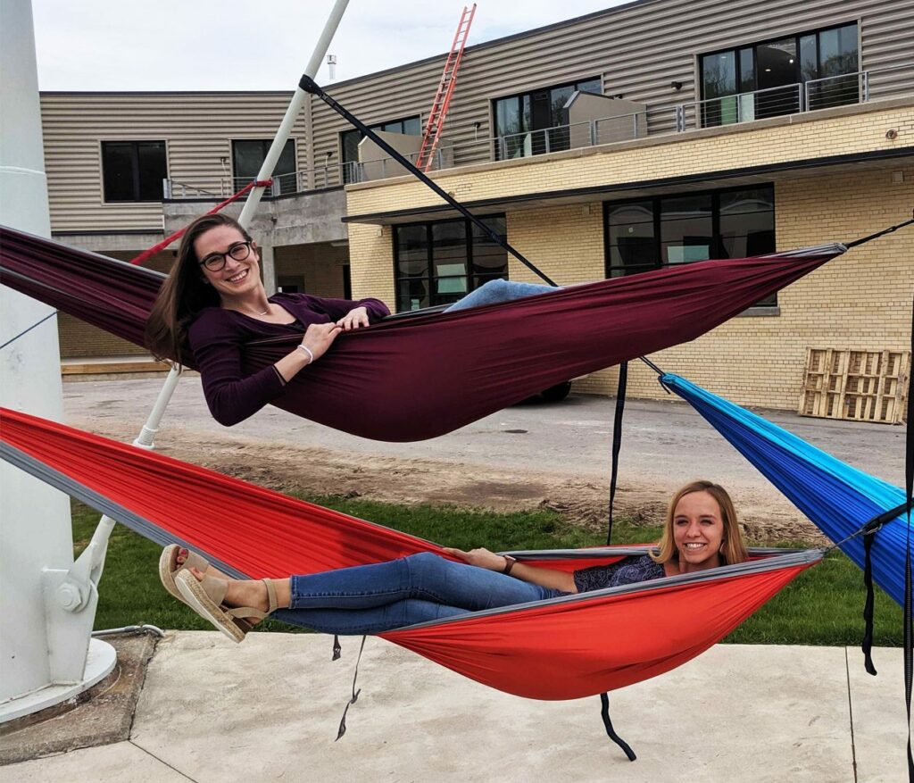 Oneupweb employees hanging out in hammocks under the water tower.