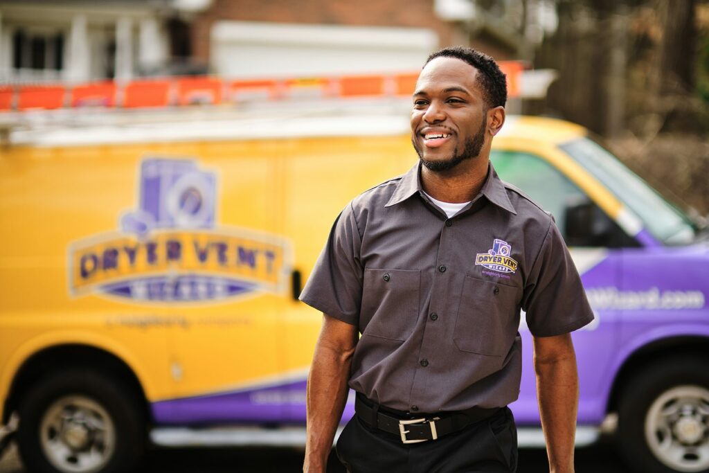 a dryer vent wizard franchise employee walks away from his branded van to work on a job