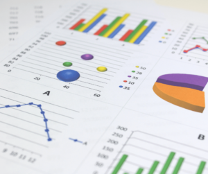 Close up of charts printed on white paper laying on a desk. 