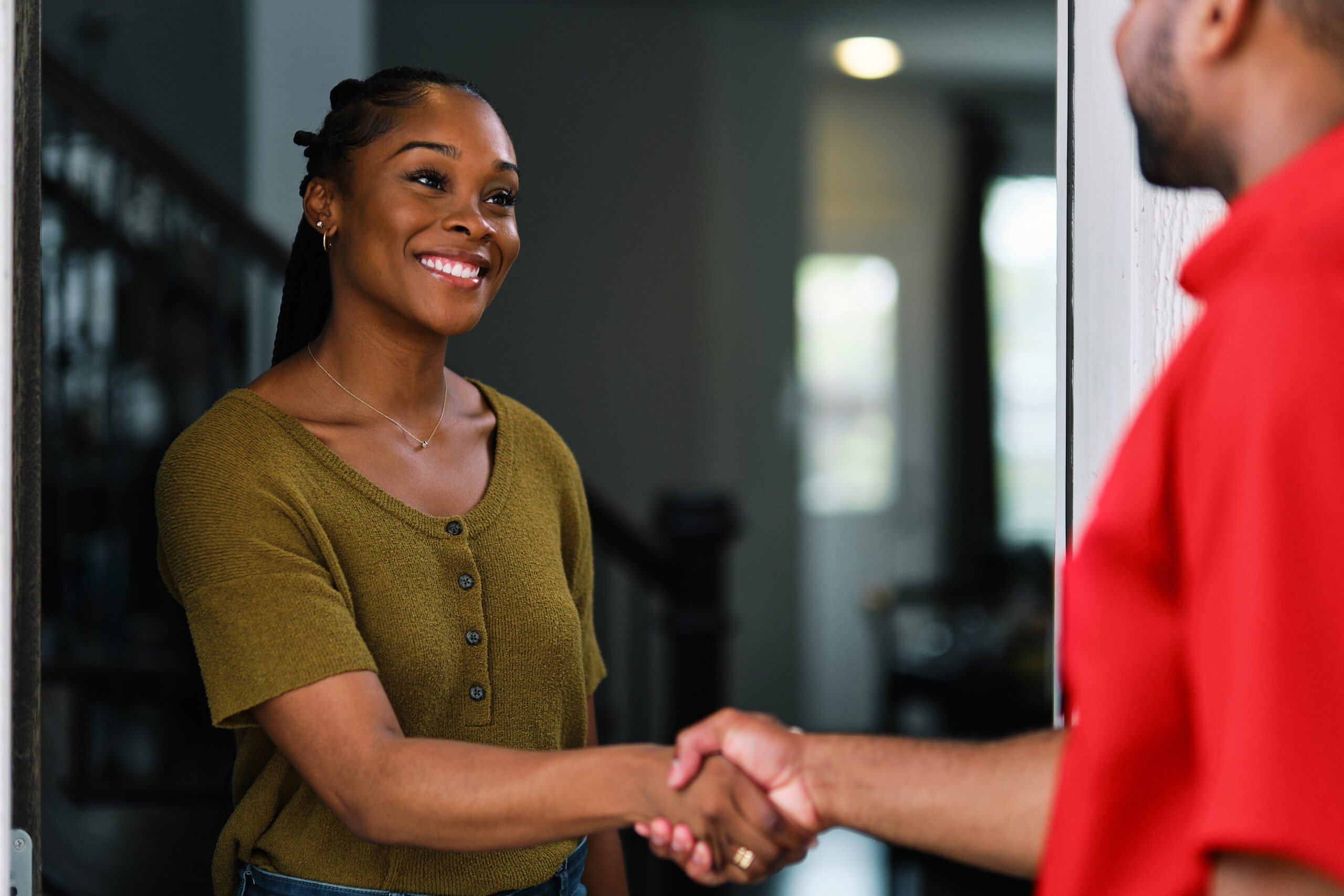 a woman greets a service worker entering her home