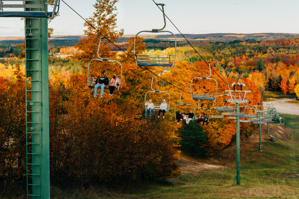 a ski lift at a ski resort during the fall advertising color tours
