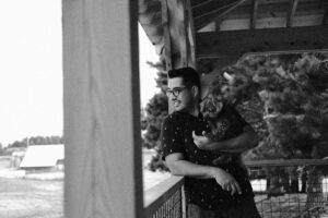 fernando meza holding his dog teddy while leaning on a porch